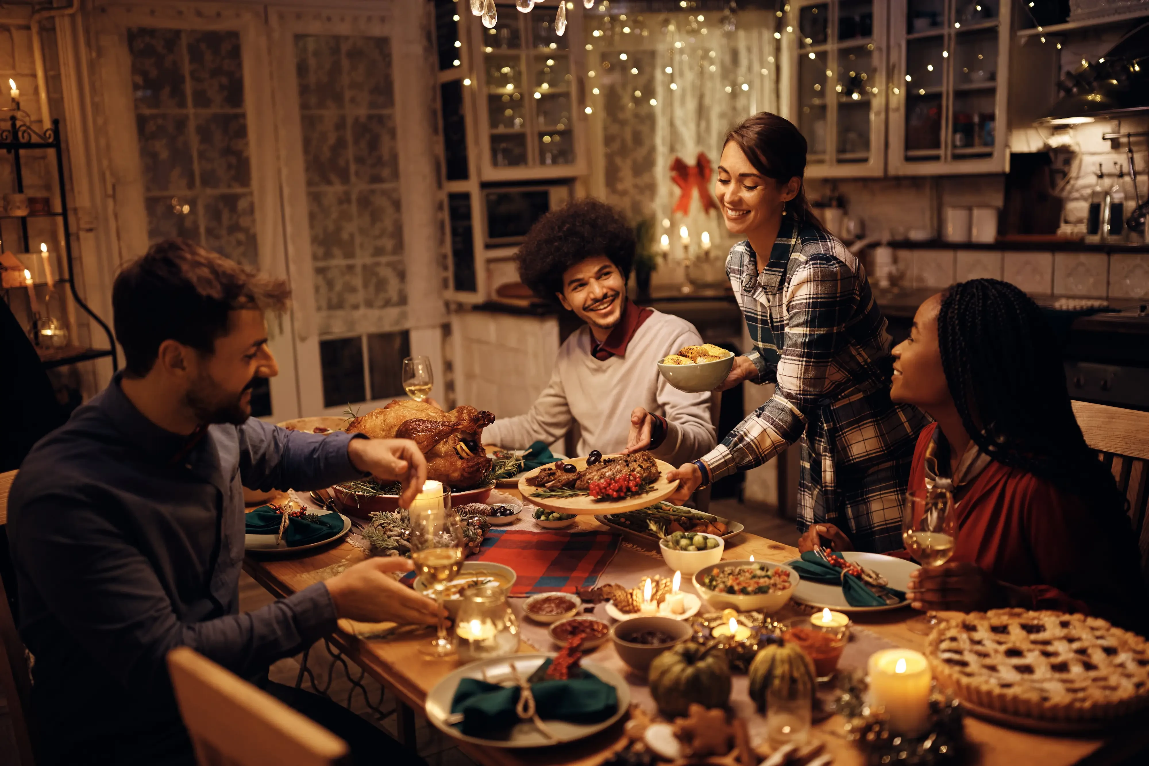 Woman passing around side dishes at Danksgiving dinner