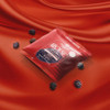 bag of male arousal gummies on red silk sheets