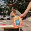 hand holding a bag of cereal squares by the pool