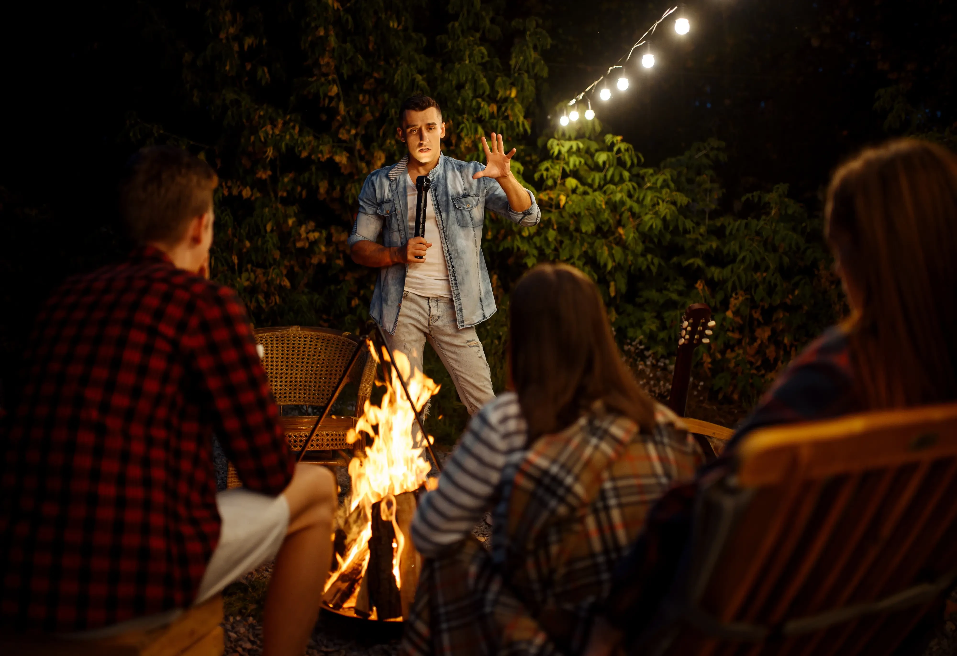 man sharing a story with friends bonfire