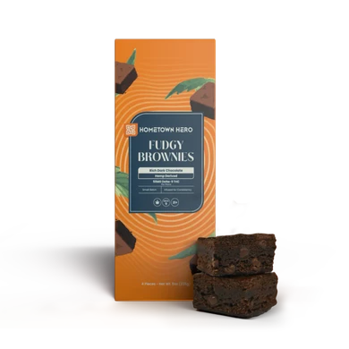 fudgy edible brownies stacked beside box