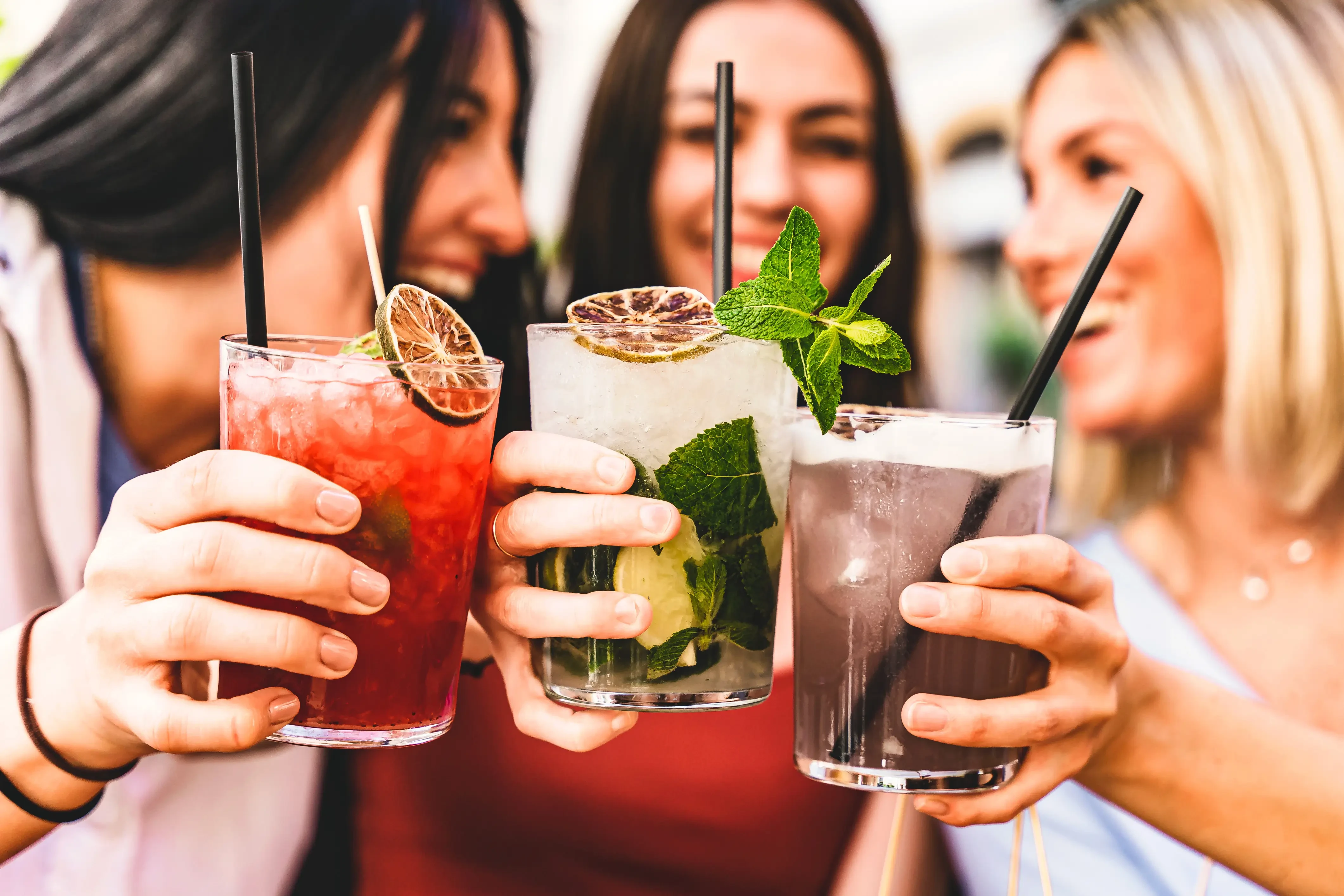 3 cannabis cocktails with 3 woman smiling in the back