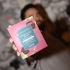 Man blurry in the background holding a Raspberry Chocolate Bites box in one hand for the camera