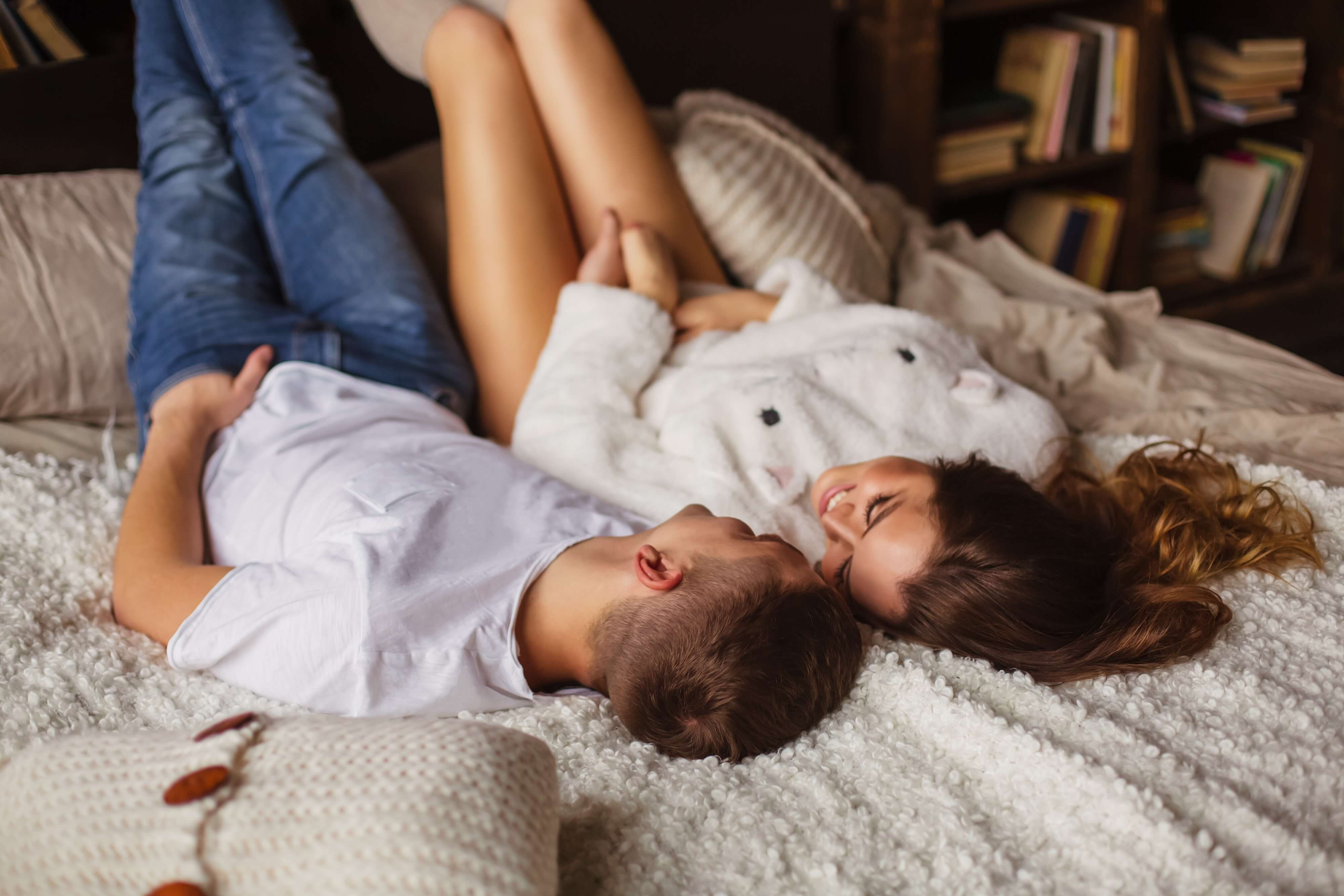 couple in bed, smiling and laughing