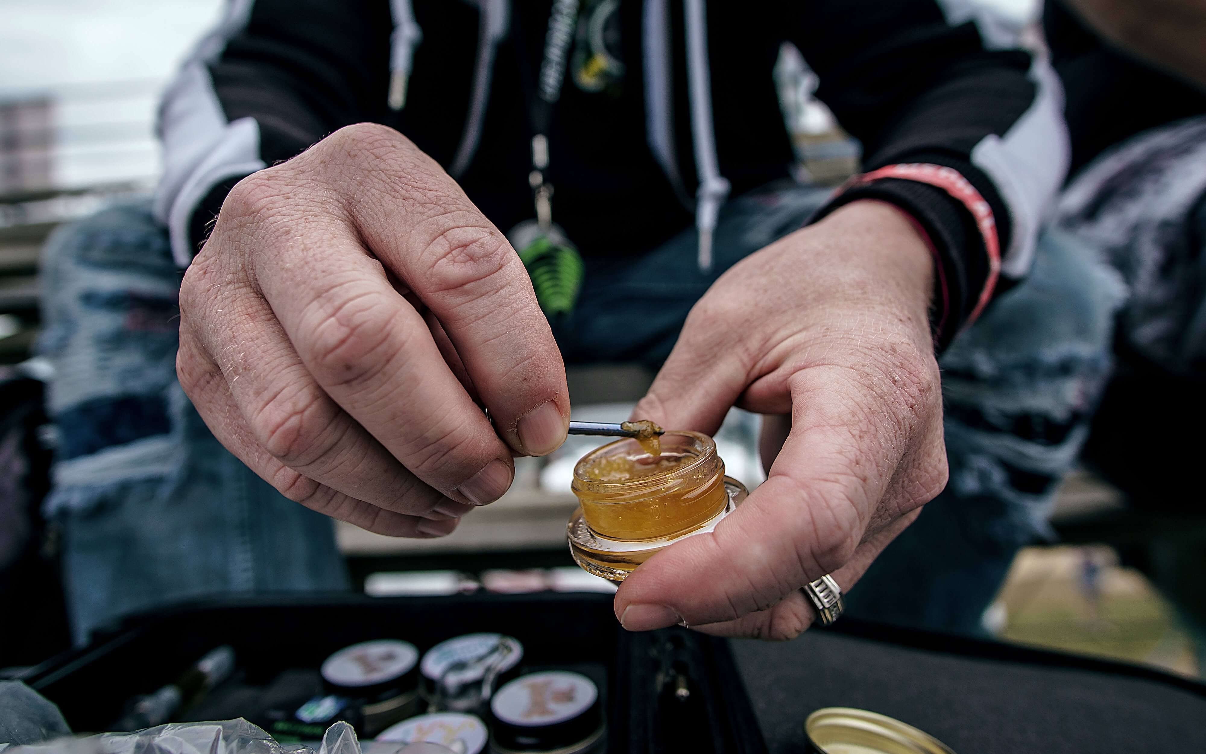 man scooping a resin dab