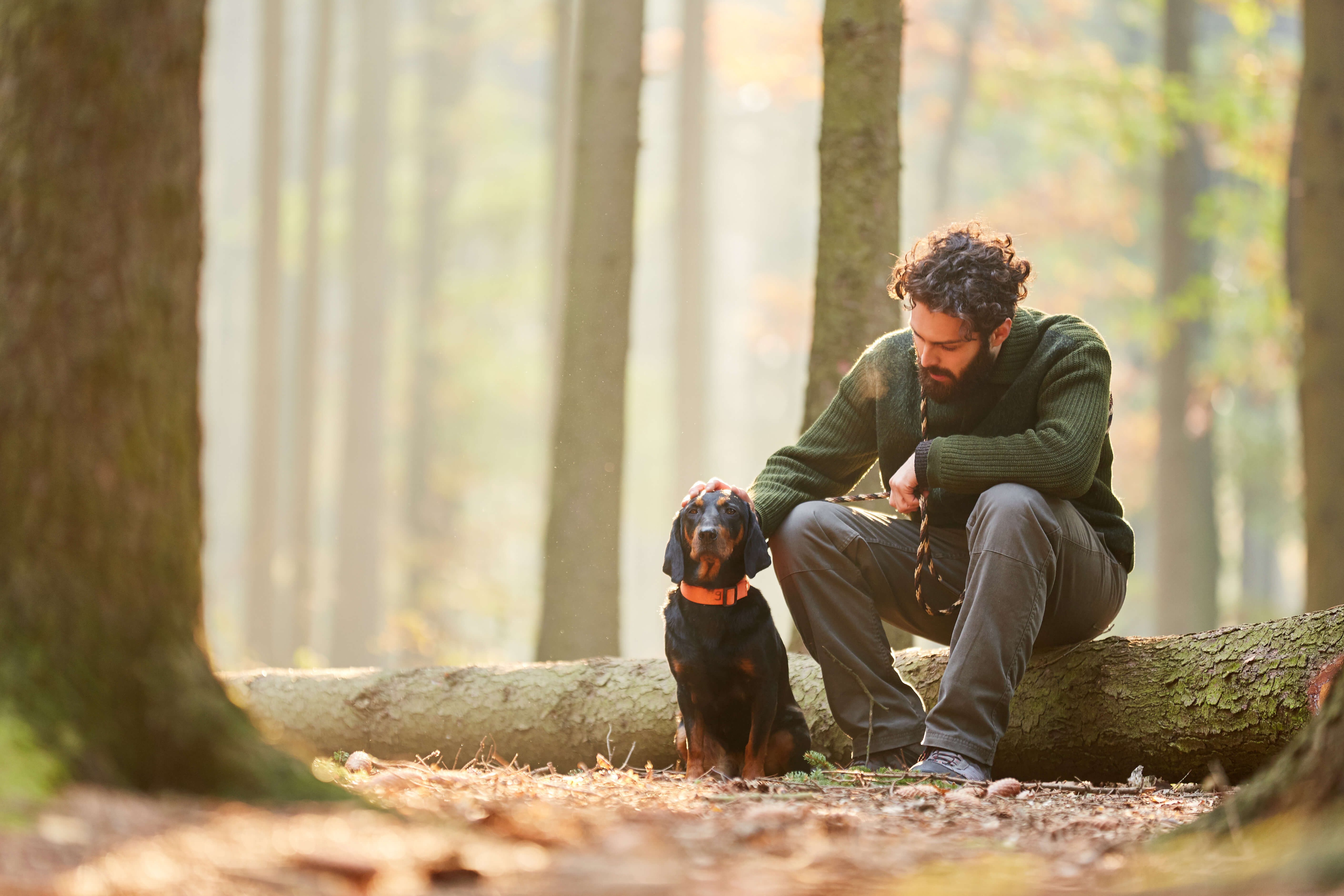 man in woods with dog
