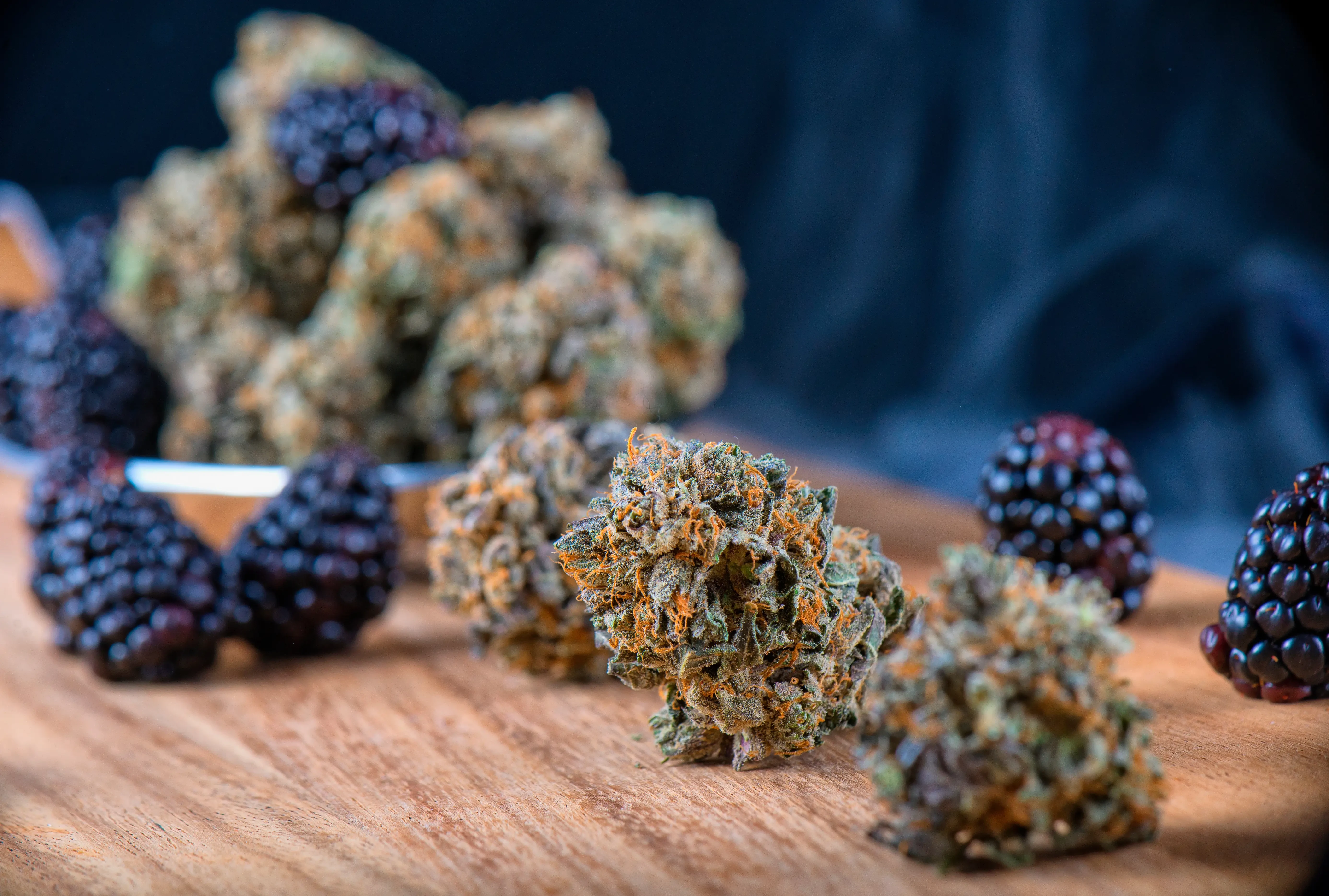 cannabis buds and blackberries on a table