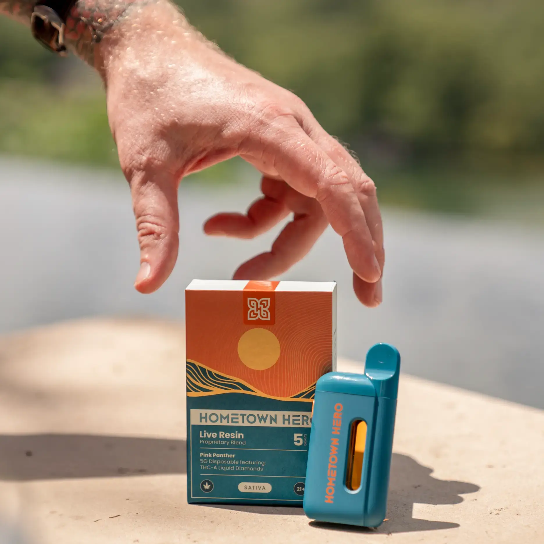 a hand grabbing a disposable box while the device is leaning on the box