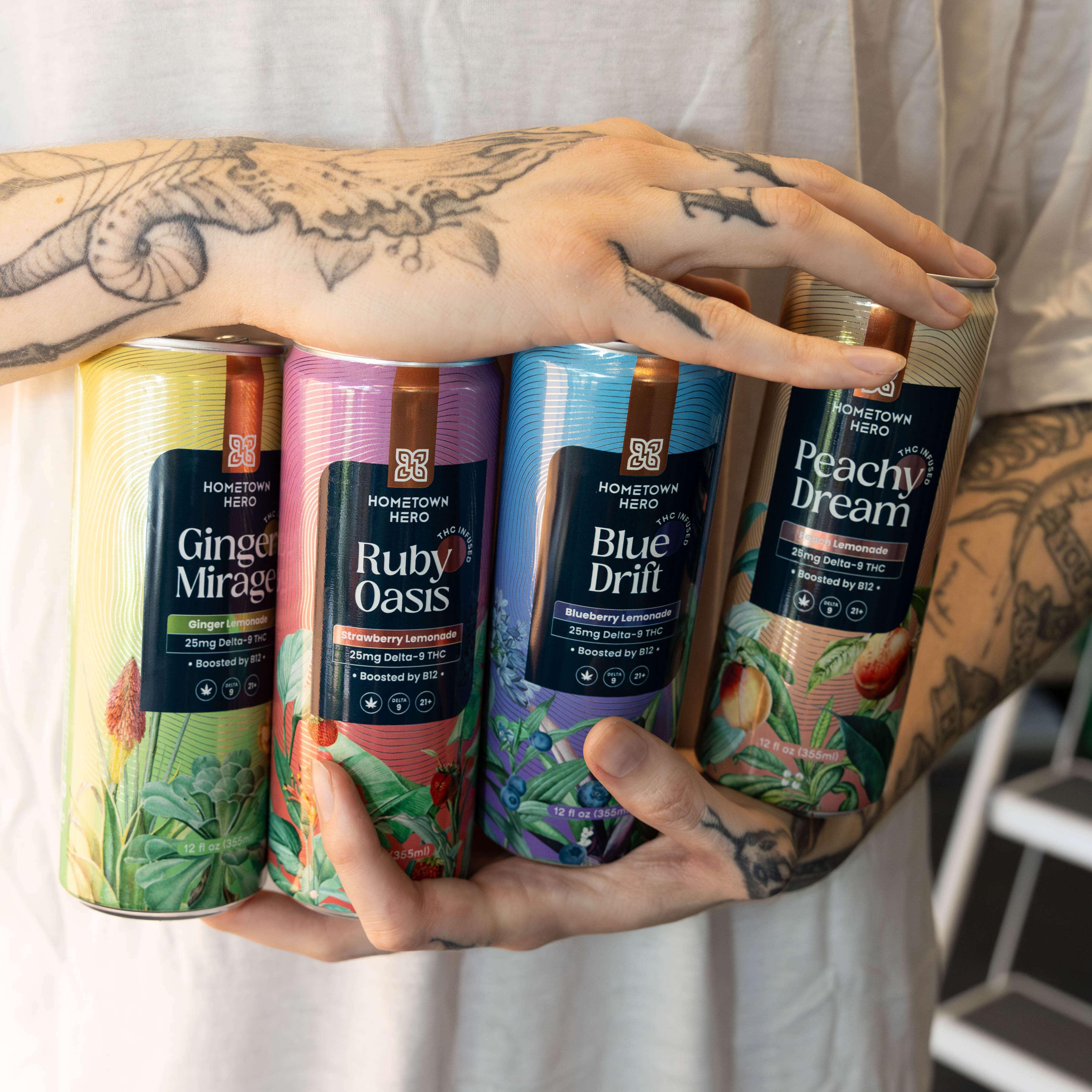 hands holding lemonade cans