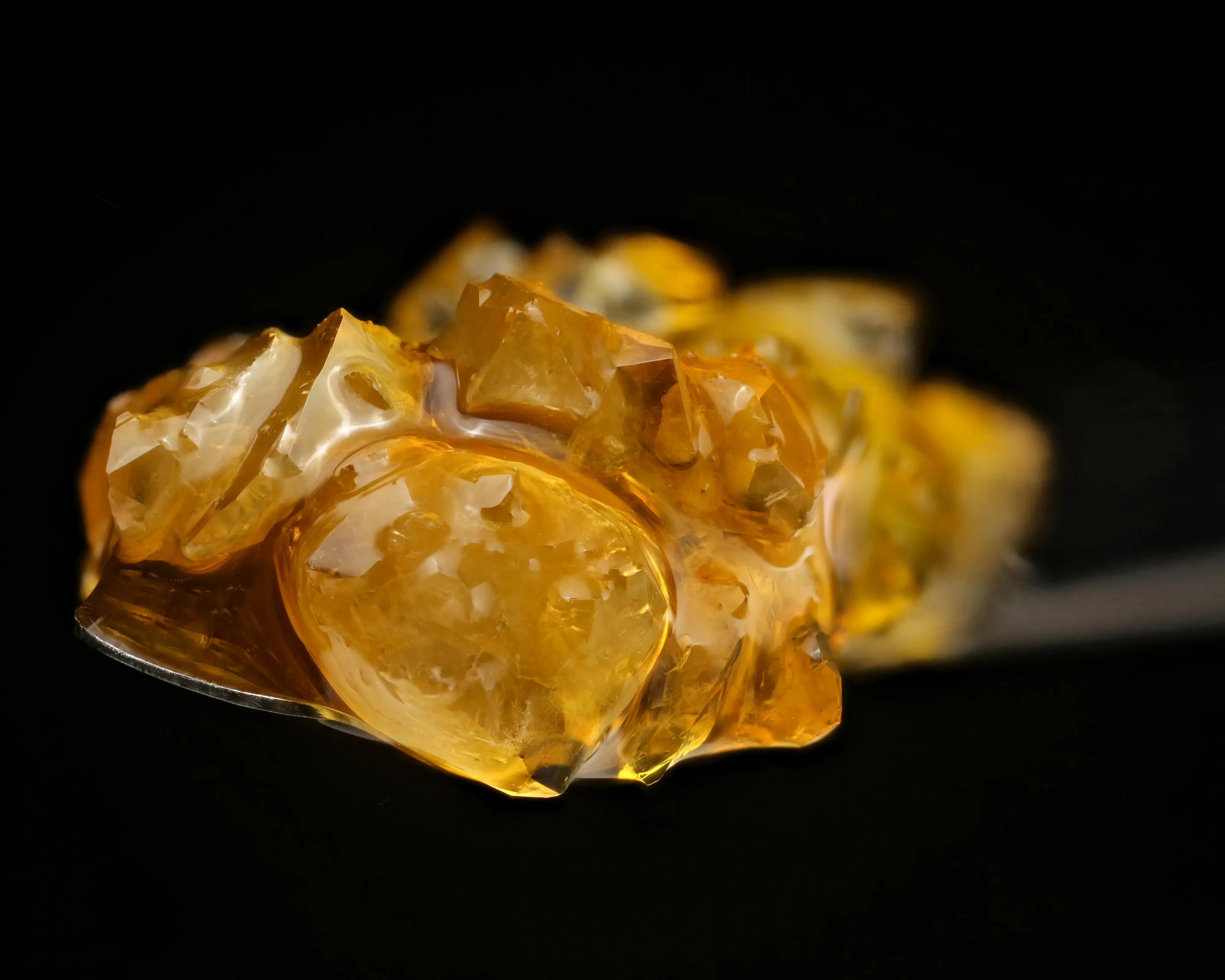 Golden, saucy cannabis concentrate dripping on a dab tool
