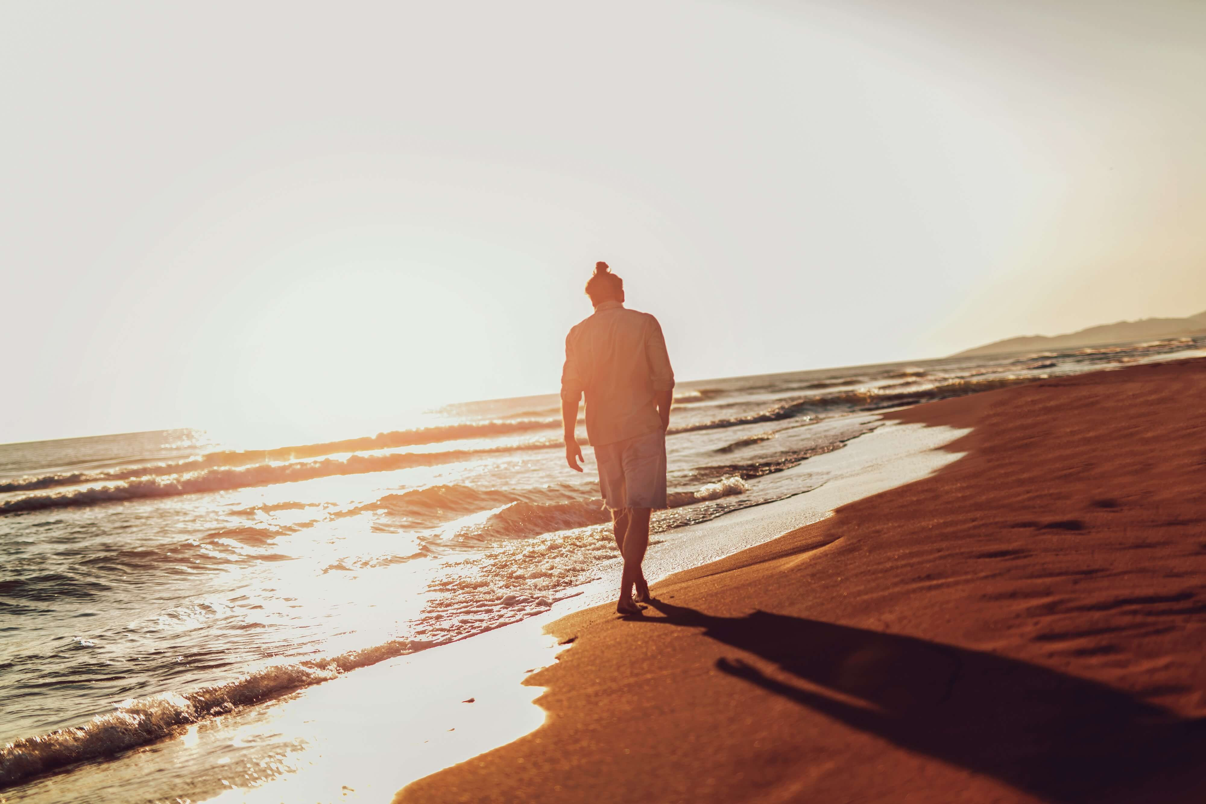 One man walking on the beach on sunset.