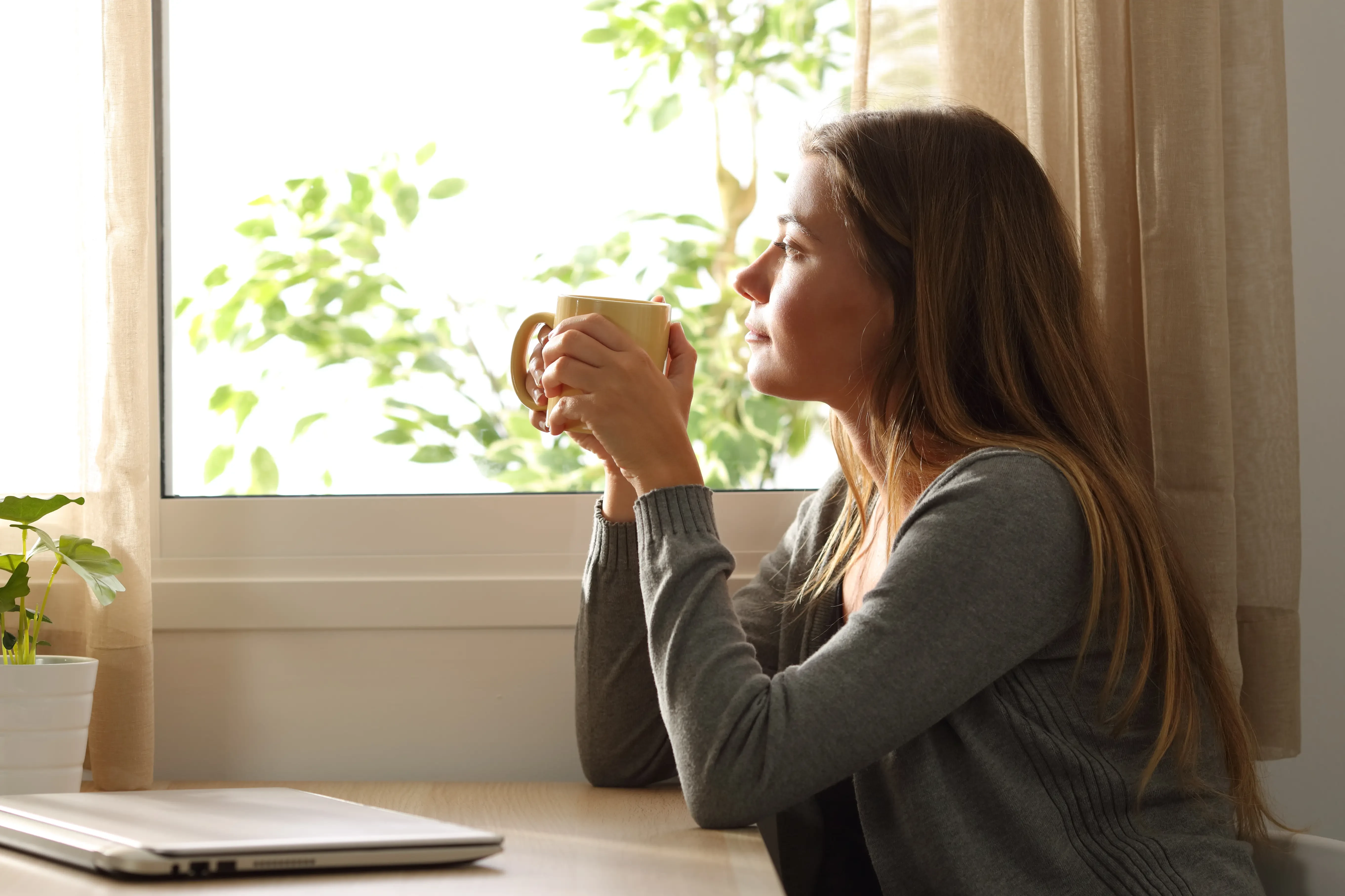 woman looking out her window, mindfully