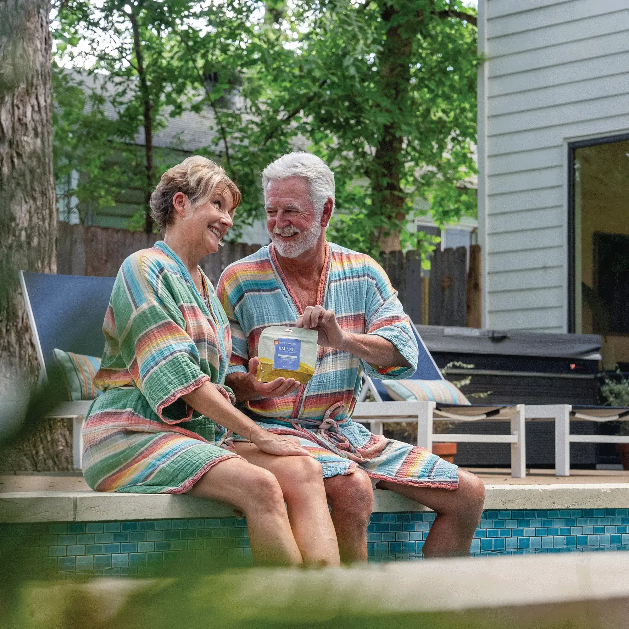 older couple by the pool sharing balance gummies