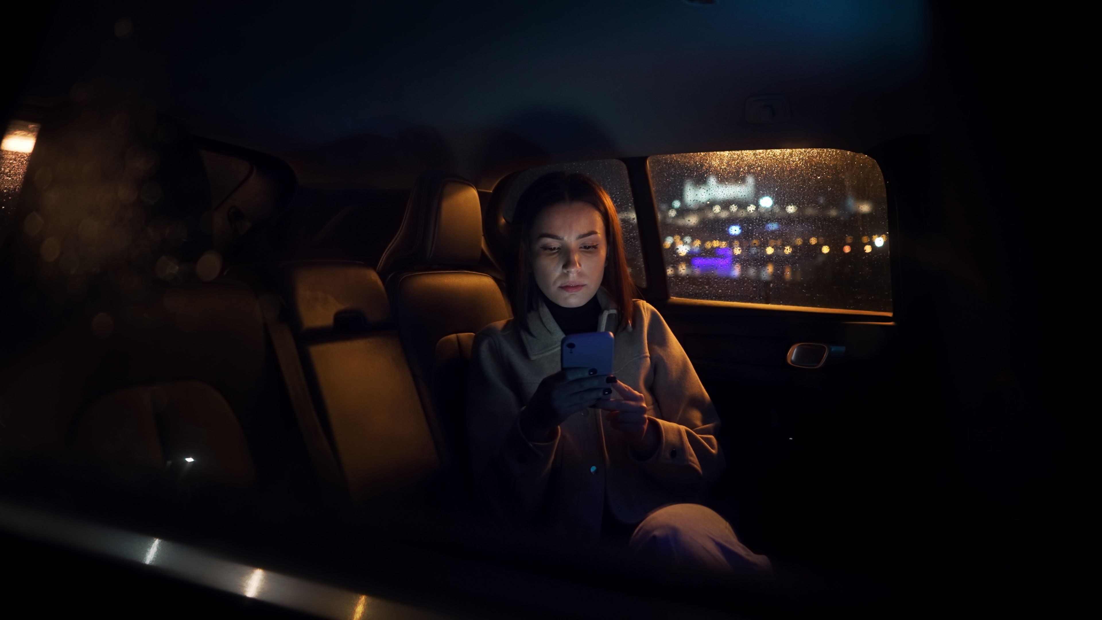 woman riding in the back of a car
