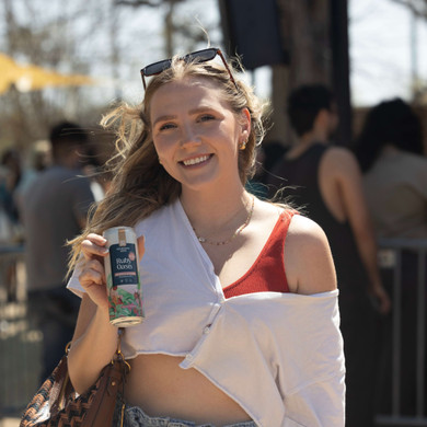 woman happily holding can of ruby oasis lemonade