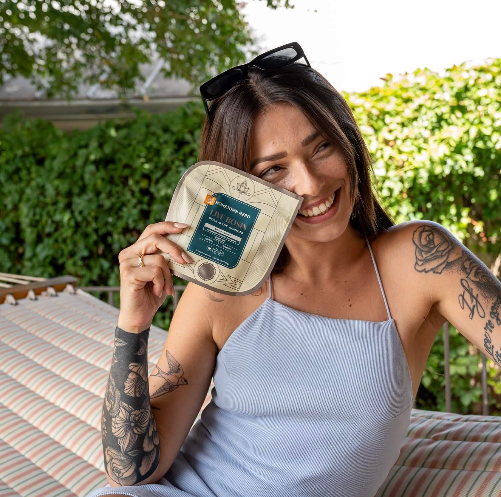 sativa gummy in hands of woman smiling