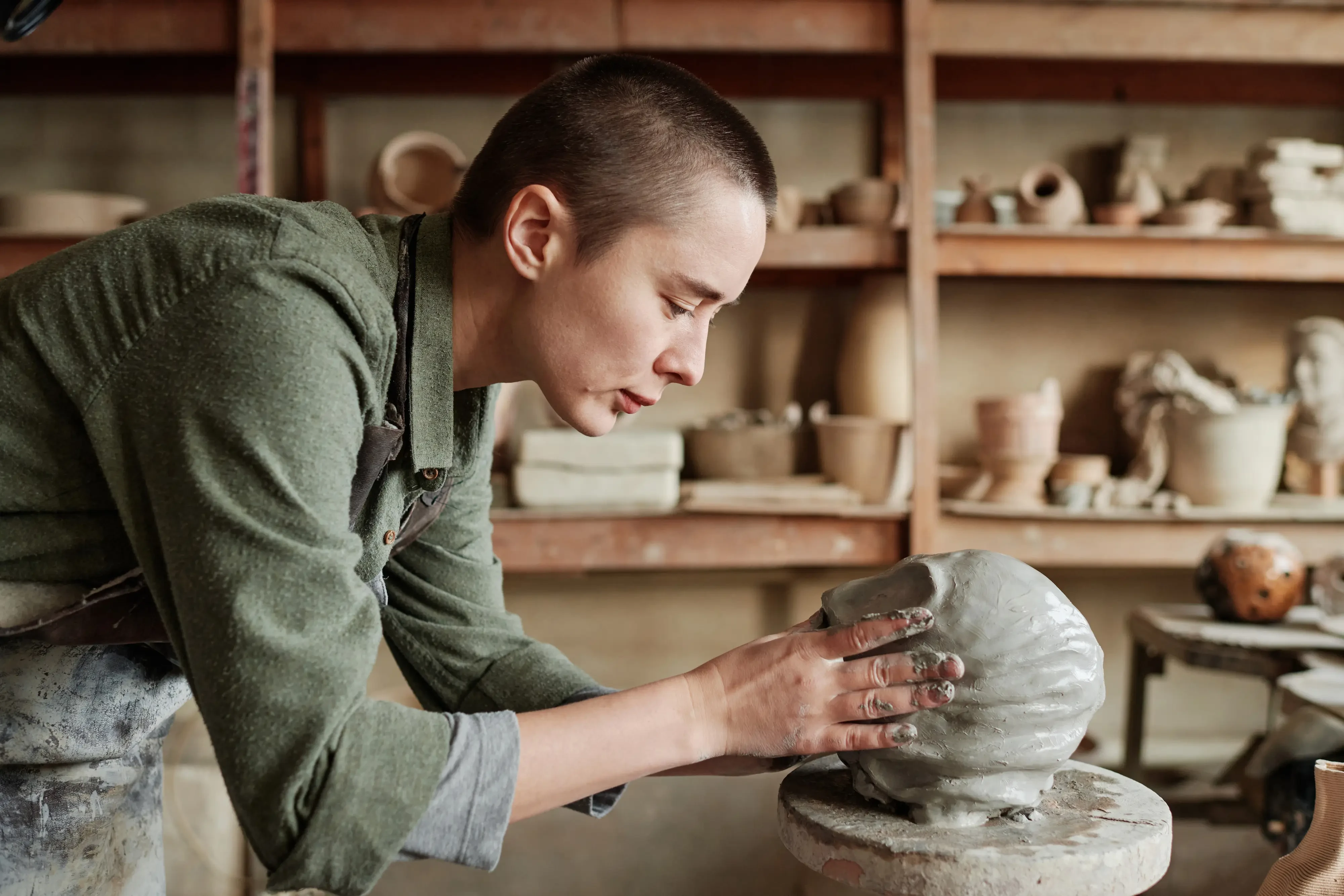 woman sculpting clay into a face