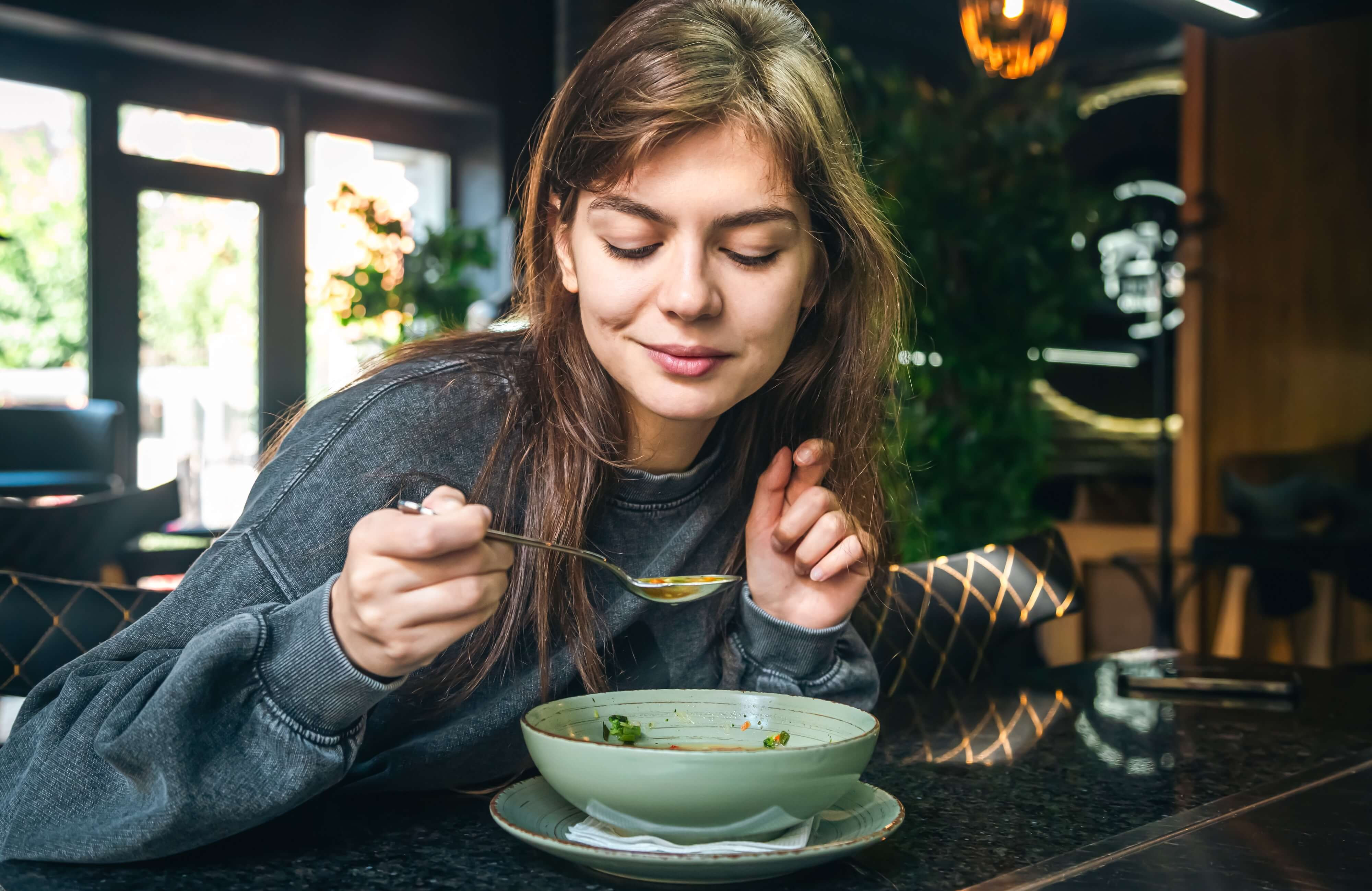 woman smiling at soup