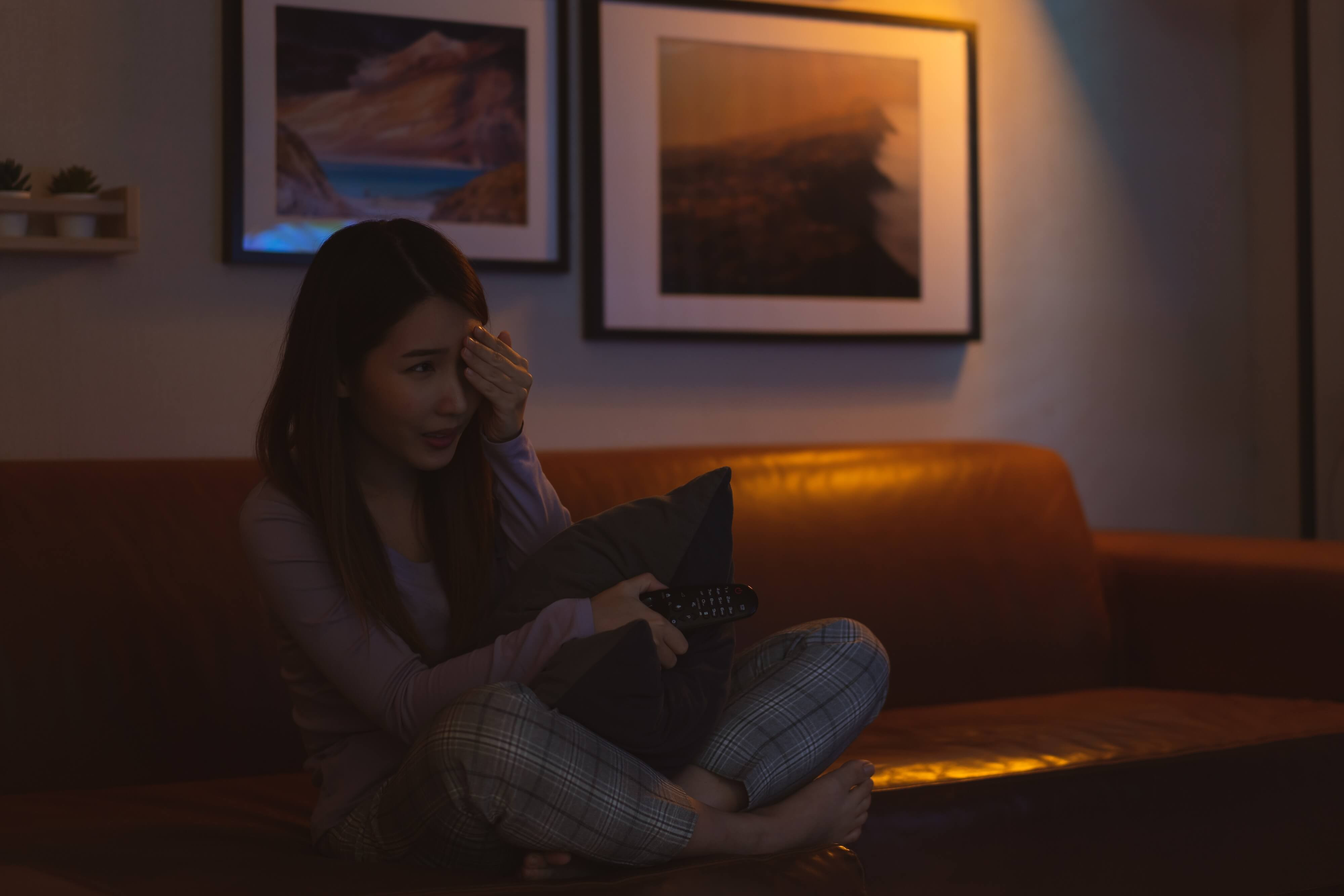 woman shuddering at a spooky movie