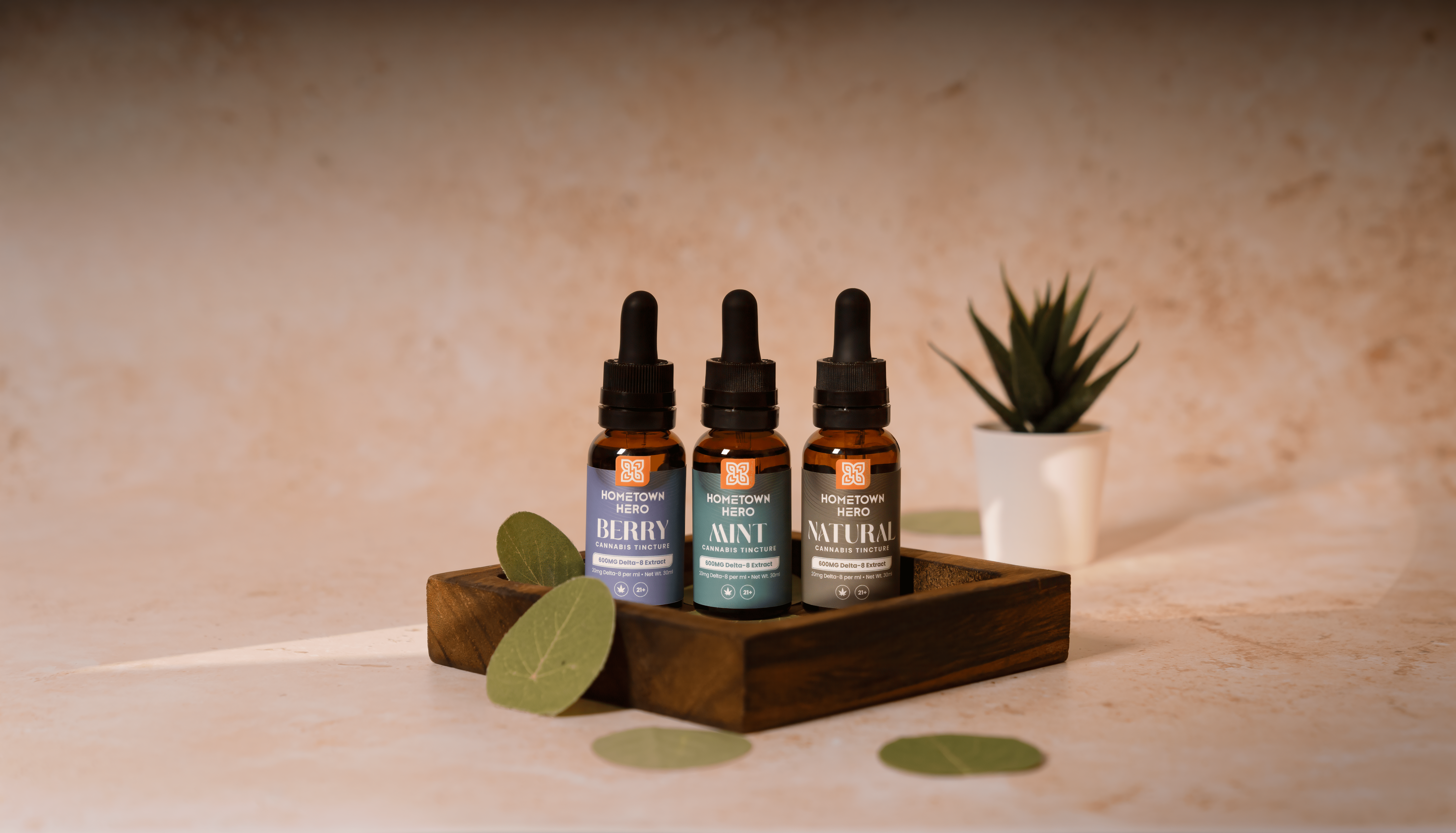 assortment of cannabis tinctures staged on a table with leaves