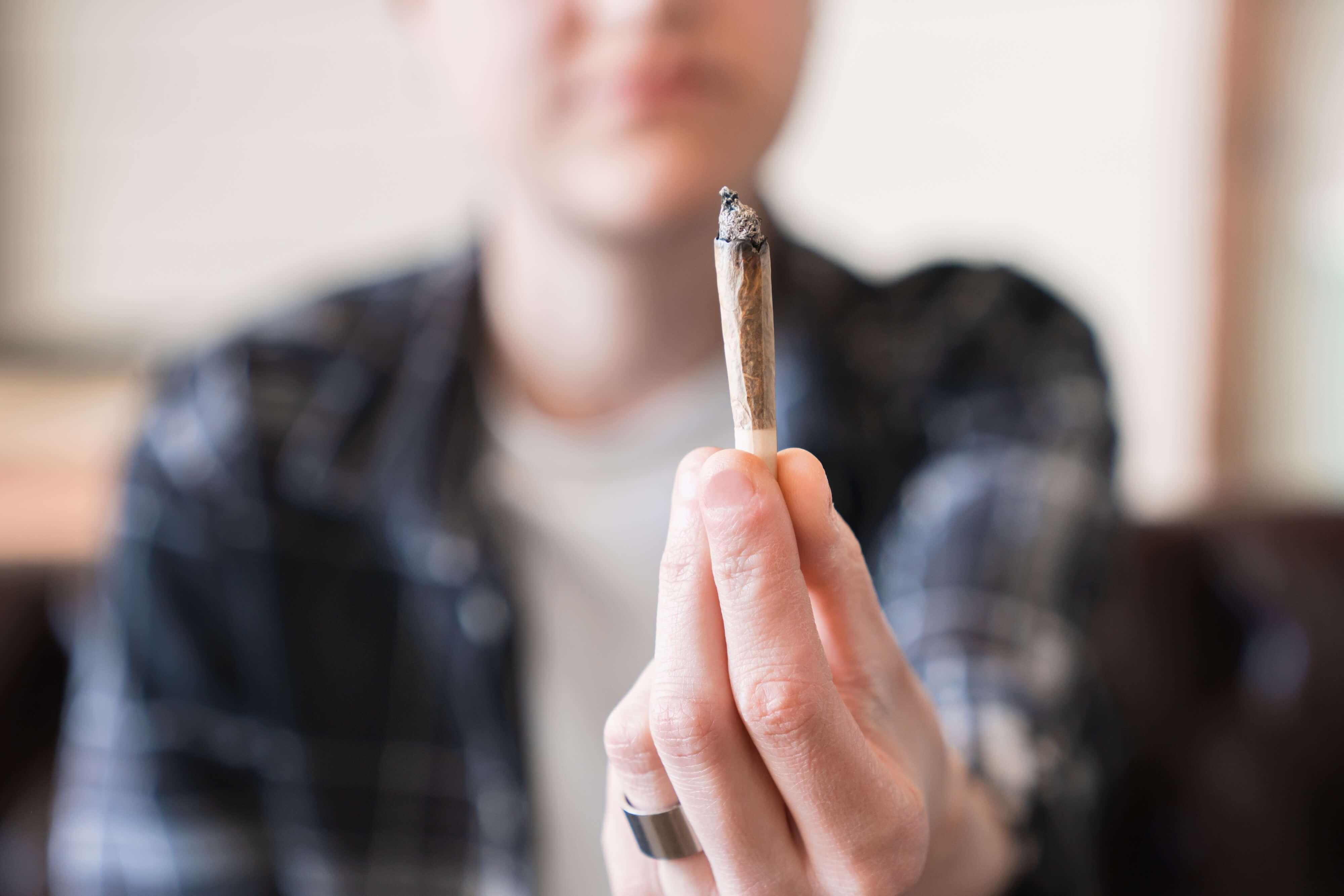 woman holding a blunt of weed
