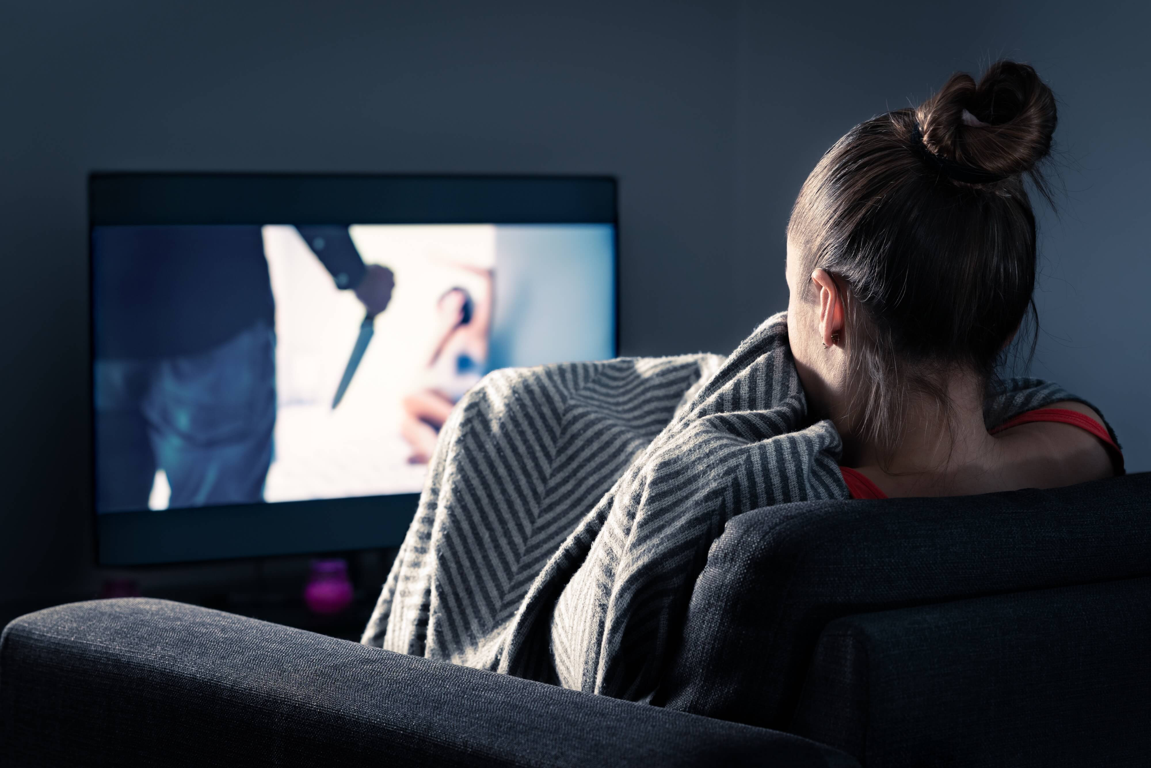 woman watching a horror movie, scared